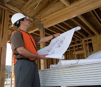 Construction crew member looking at blueprints.